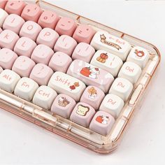 a pink and white computer keyboard with hello kitty stickers on it's keys