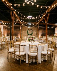 the tables are set up with white linens and gold chairs for an elegant reception