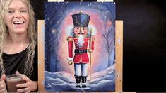 a woman holding a cup next to a painting of a nutcracker in the snow