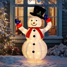 a lighted snowman in front of a house