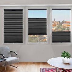 a living room with three windows that have black blinds on them and a chair in front of the window