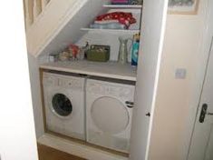 a small laundry room with two washers and a dryer in the closet area