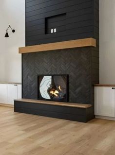 a modern fireplace in a living room with wood flooring