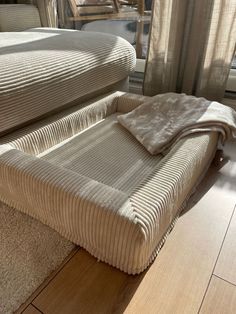 a bed sitting on top of a wooden floor next to a window