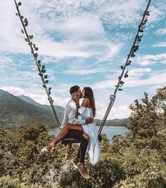 two people sitting on a swing in the air