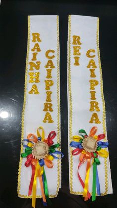 two white sashs with ribbons on them and the words rancara written in gold