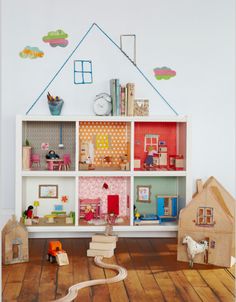 a doll house is on top of a bookcase in the corner of a child's room