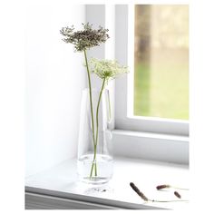 a vase with some flowers in it sitting on a window sill