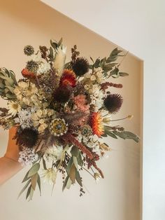 a woman holding a bouquet of flowers in her hand