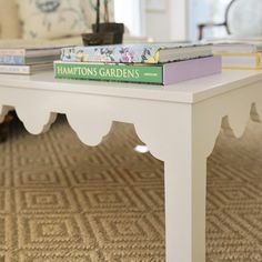 two books are sitting on top of a coffee table in a room with beige carpet