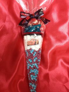 a plastic bag filled with candy and candies on a red cloth covered tablecloth