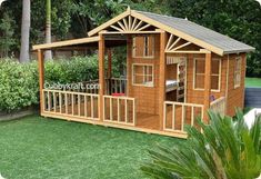 a small wooden shed sitting on top of a lush green field