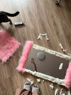 a person standing on the floor next to a mirror with pink fur trimming around it