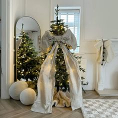 a decorated christmas tree in the corner of a room with white decorations and lights on it