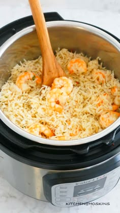 shrimp and rice in an instant pot with a wooden spoon on the side, ready to be cooked