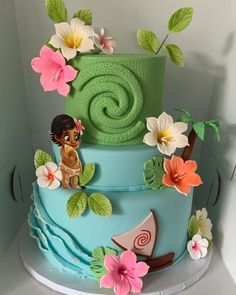 a blue and green cake with flowers on it