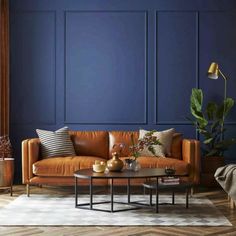 a living room with blue walls and leather furniture in the corner, including a coffee table