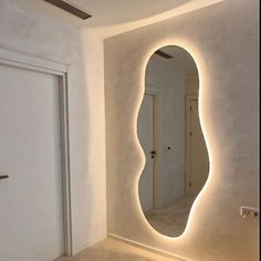 a mirror that is on the side of a wall next to a door with lights