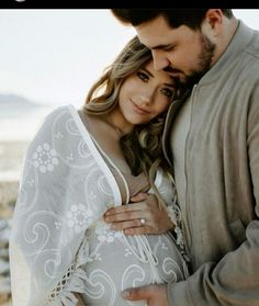 a man and woman embracing each other on the beach