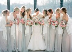 a group of women standing next to each other holding bouquets