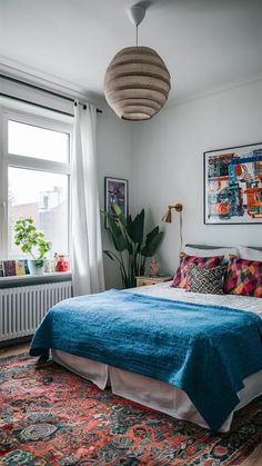 a bedroom with a bed, rugs and paintings on the wall above it's headboard