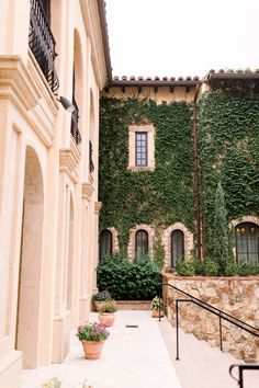 an outdoor courtyard with potted plants on the side and stairs leading up to it