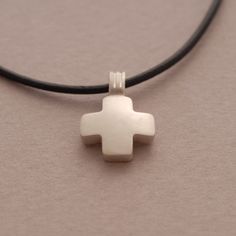 This chunky but tiny cross pendant is a subtle, minimalist necklace that can easily be worn everyday or layered with other necklaces. The dainty cross is handmade of 925 Sterling silver and with a smooth matte finish. In keeping with the purity of the piece, the cross comes on a genuine leather strand in your choice of black or other colors and has been finished nicely with a sterling silver clasp closure and endings. Leather cord 42 cm L (if you require a longer cord, simply request for no addi Minimalist Sterling Silver Cross Pendant Necklace, Simple Sterling Silver Cross Pendant Necklace, Simple Everyday Cross Jewelry, Simple Everyday Cross Pendant Necklace, Minimalist Nickel-free Cross Necklace, Minimalist Sterling Silver Cross Necklace, Simple Everyday Cross Necklace, Everyday Cross Pendant Charm Necklace, Minimalist Sterling Silver Pendant Cross Necklace