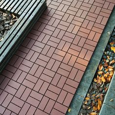 a bench sitting next to a pile of leaves on top of a wooden floor covered in mulch