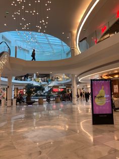 the inside of a shopping mall with people walking around