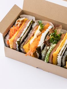 a box filled with lots of different types of sandwiches