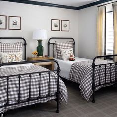 two beds in a bedroom with black and white checkered sheets on the bedding