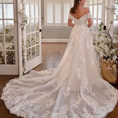 a woman in a wedding dress looking out the window