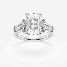 an engagement ring with three stone diamonds on the shoulders and side stones, set in 18k white gold