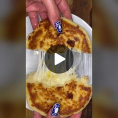 someone holding up a pizza with cheese on it in front of a video player's hand