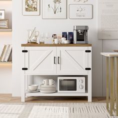 a kitchen with white walls and pictures on the wall above it, including a microwave