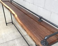 a wooden bench sitting next to a brick wall with iron bars on it's sides