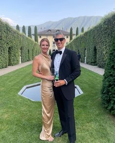 a man in a tuxedo standing next to a woman in a gold dress