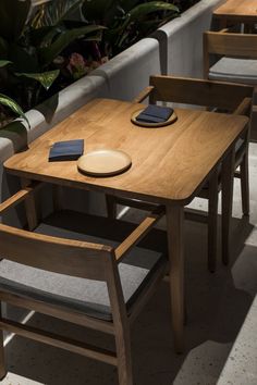 a wooden table with two chairs and a plate on top of it next to a couch