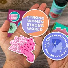 two hands holding stickers that say strong women, strong men and strong women in the world