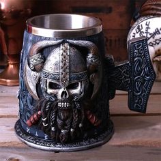 a metal mug with a skull in the middle and a beard on it's side