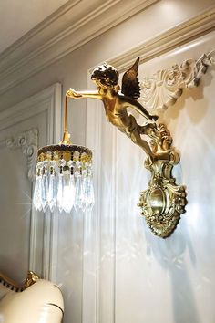 a wall light that is next to a chandelier in a room with white walls