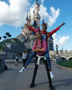 two people posing for a photo in front of a castle