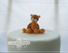 there is a small cake with a toy tiger on it