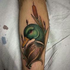 a green duck sitting on top of a person's leg