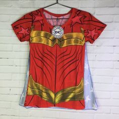 Up For Grabs Is A Brand New With Tag Dc Comics Wonder Woman Graphic Print Lightweight Short Sleeve Tee T-Shirt With Detachable Cape Women's Juniors Size Medium. Never Worn Or Used. Measurements Laying Flat Are Included In Photos, Please Compare Them To Your Own For Proper Fit! Please Refer To All Photos. Ask Any Questions Prior To Purchasing. Thanks! Red Graphic Print T-shirt For Fan Conventions, Superhero Short Sleeve T-shirt With Character Print, Blue Superhero T-shirt With Character Print, Casual T-shirt For Comic-con, Pop Culture Anime Print Tops For Conventions, Pop Culture Anime Print Tops For Fan Conventions, Fun Short Sleeve T-shirt With Anime Print, Cotton Top For Comic-con Fan Merchandise, Cotton Tops For Comic-con Fan Merchandise