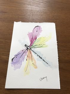 a watercolor painting of a dragonfly on white paper