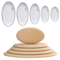 five white plates sitting on top of each other next to an object in the shape of a stack