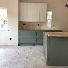 an empty kitchen with white cabinets and wood counter tops in the process of remodeling