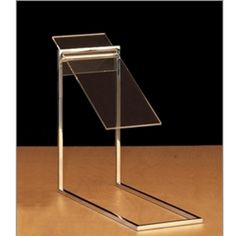 a clear glass and metal stand on a wooden table with a black background behind it