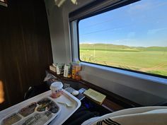 an empty tray with food on it in front of a window overlooking a green field